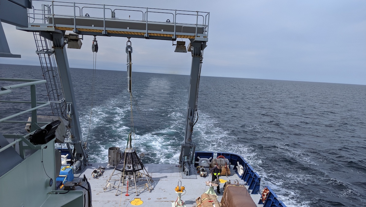 The back deck of a boat as it moves through the ocean.
