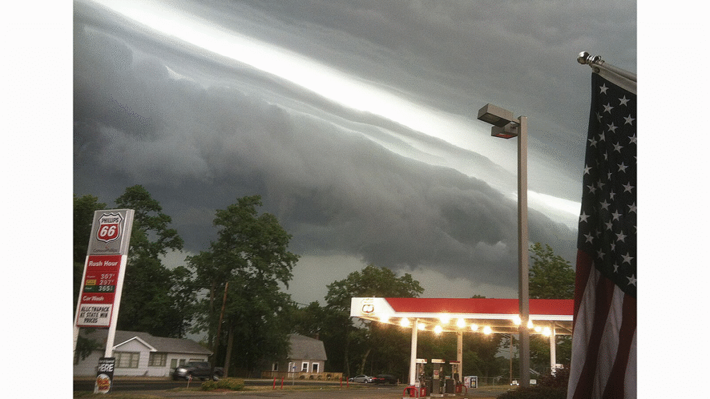 Photo of a gas station with dark storm clouds looming above.