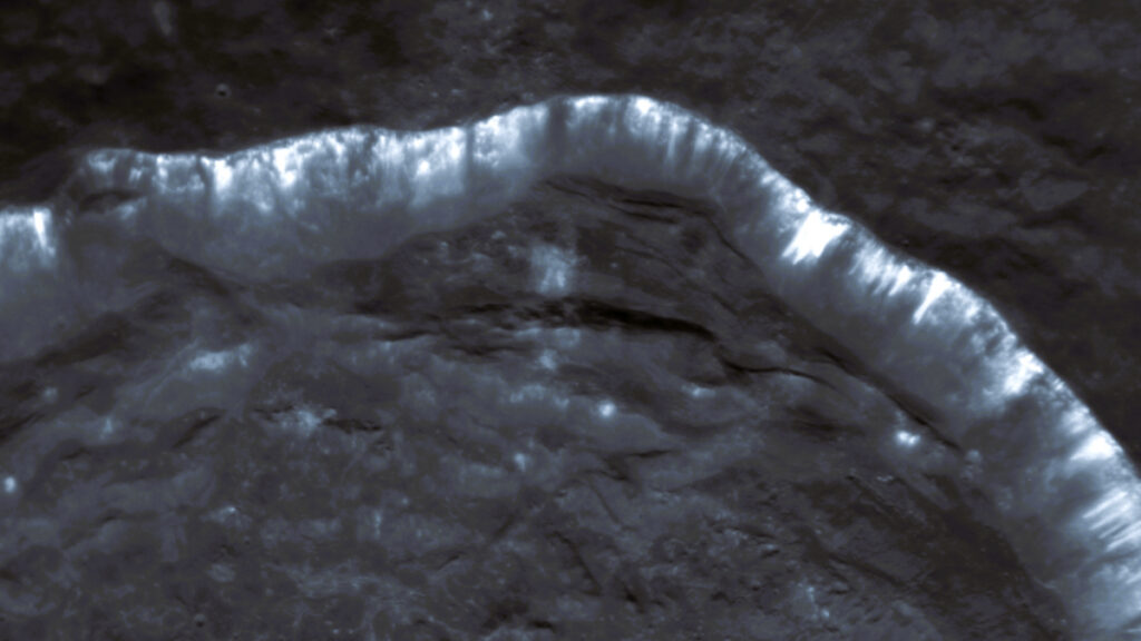 Roughly a quarter of a crater rim with blue-white streaks pointed inward.