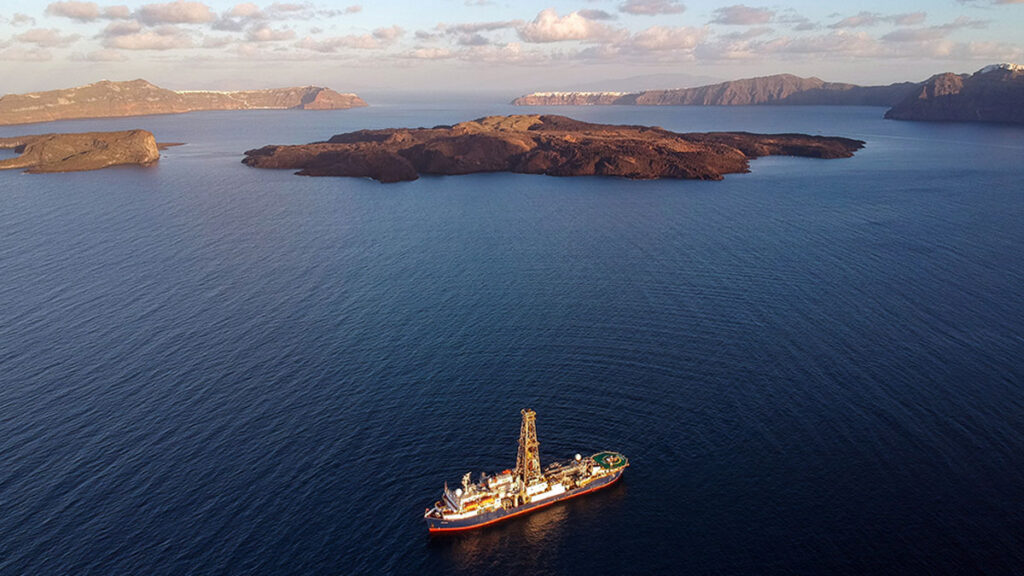 A large ship on the ocean, with various islands in the background