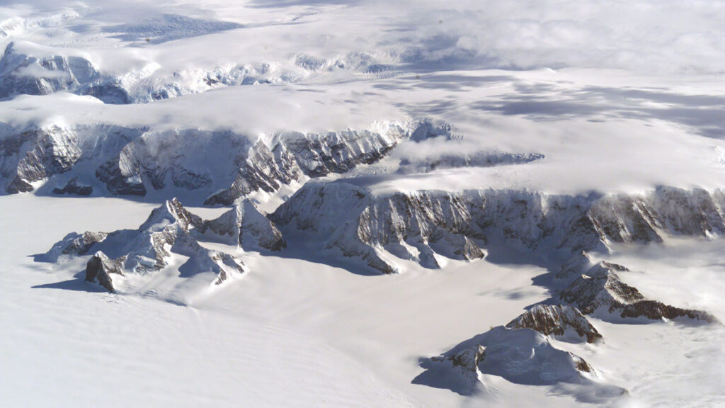 An aerial photo shows a snow- and ice-covered mountain range.