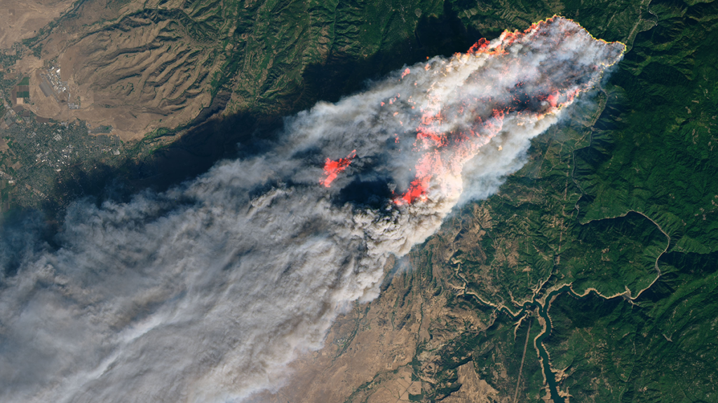 Aerial photo of smoke billowing from a wildfire.