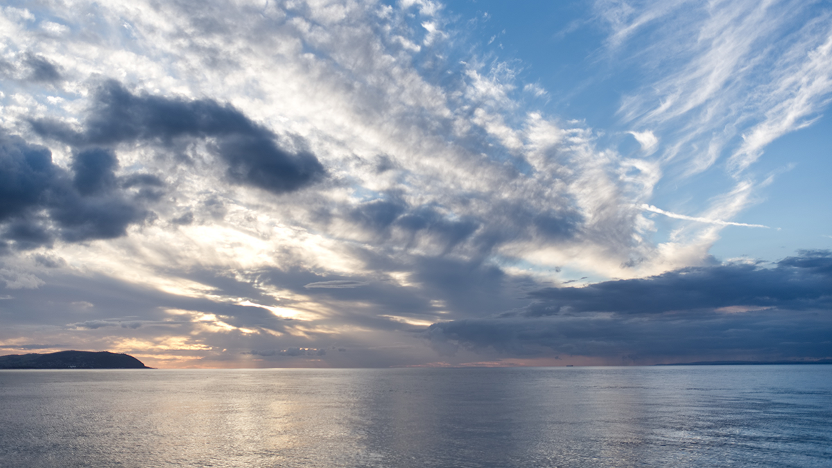 Clouds above a body of water.