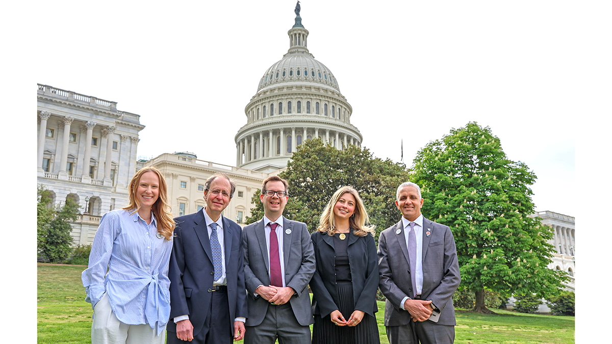 A photo of 5 people in front of the US Capital.