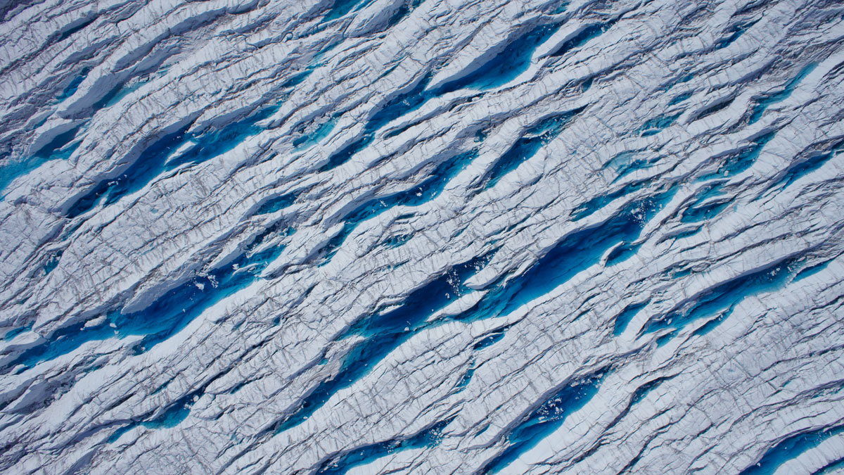 Crevasses on a glacier are seen from overhead.