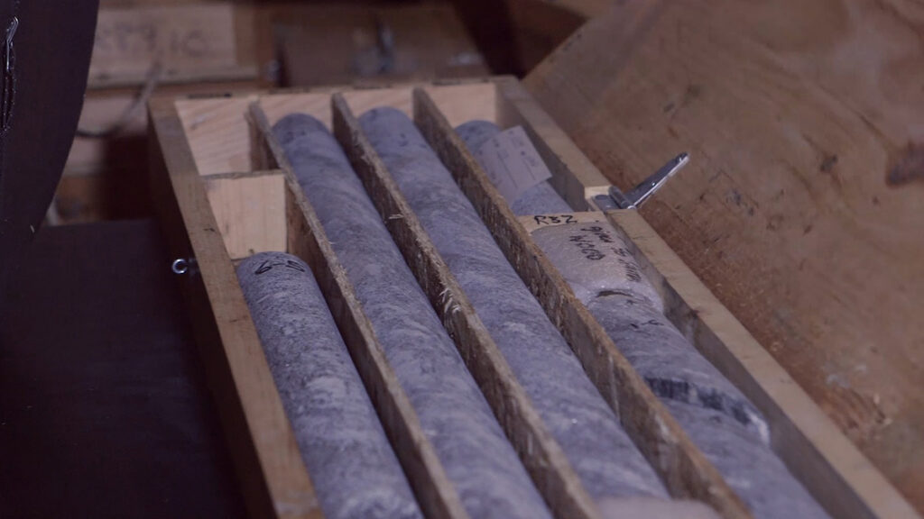 Rock core samples are arranged in trays for analysis.