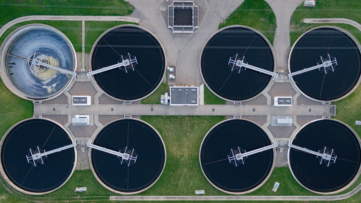 An aerial photo shows eight large vats of water that make up a wastewater treatment plant.