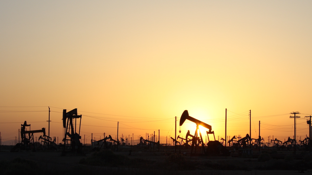 An oil field with pumpjacks at sunset.
