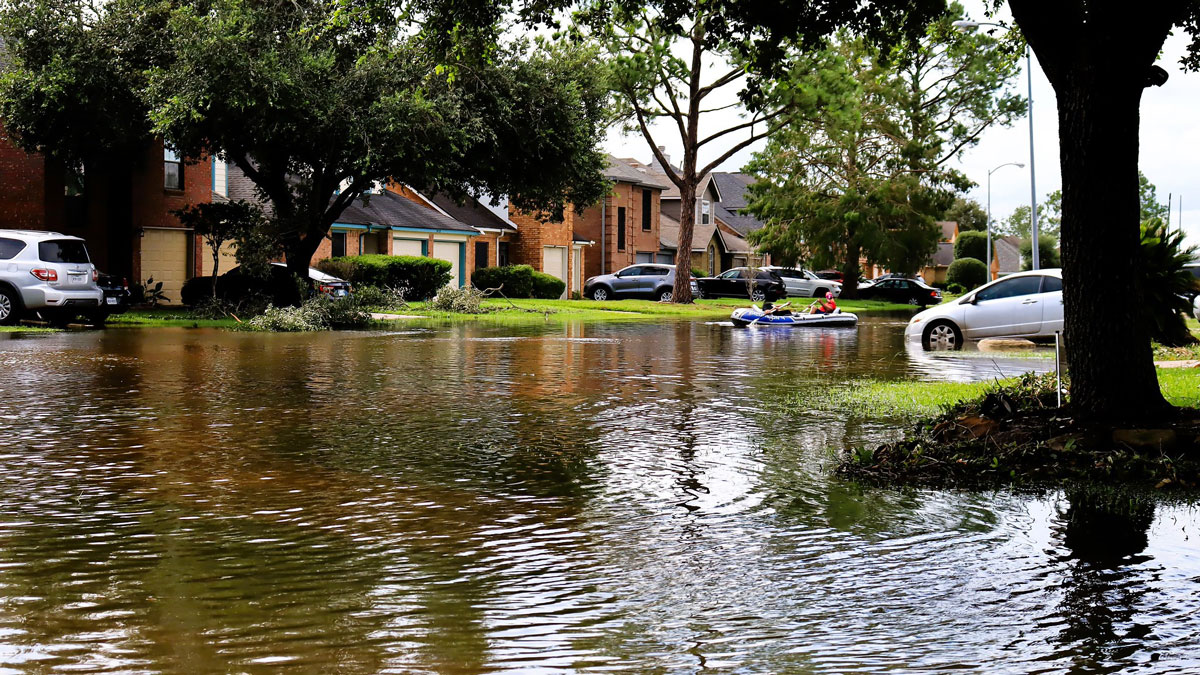 People raft down a flooded residential street in Houston in the aftermath of Hurricane Beryl.
