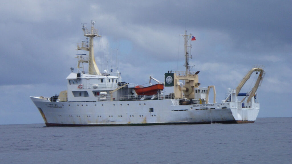 A large white research vessel out at sea on a gray day.