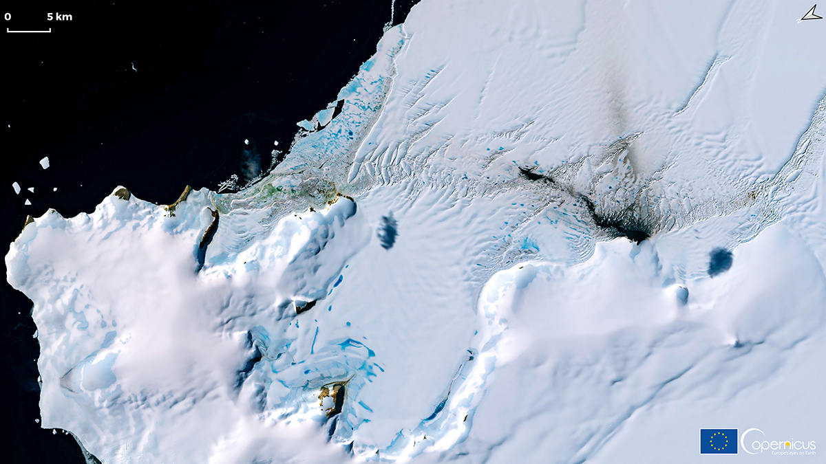 A satellite image shows a white ice shelf with tinges of blue; the surrounding ocean is dark blue, nearly black. Logos for the European Union and the Copernicus satellite program appear in the bottom right corner.