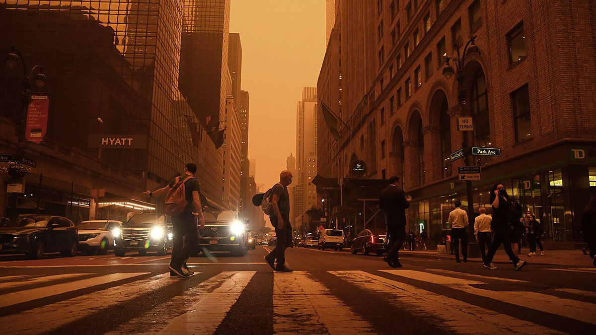 New York City residents cross 42nd Street at Grand Central Terminal under orange skies caused by smoke from wildfires in Quebec.