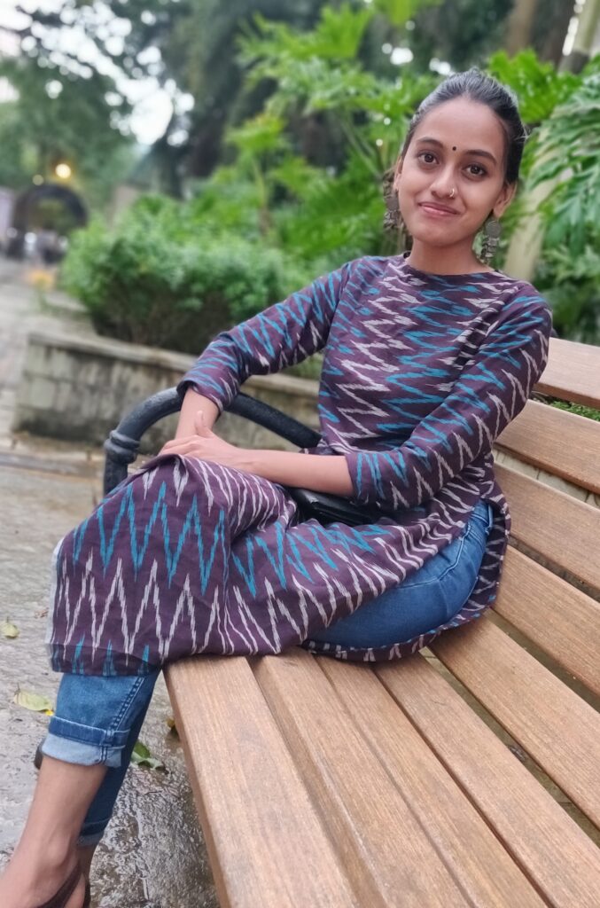 An Indian woman sits on a bench.