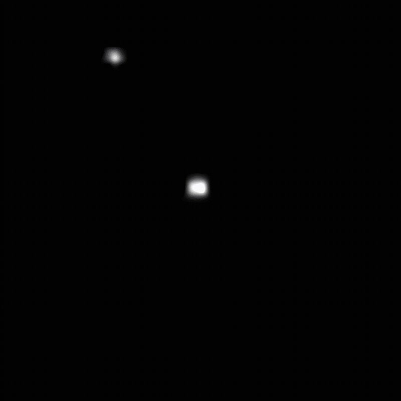 A repeating video of a small white dot moving diagonally from top left to bottom right and passing in front of a stationary white dot that sits in the center.