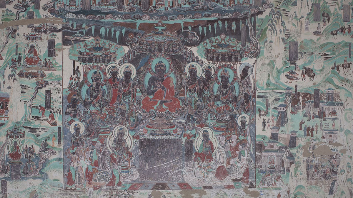 A photograph of a mural shows a wide array of people and activities, including Buddha preaching to a group of people, people walking along a path with horses, and natural features such as trees, mountains, and water.