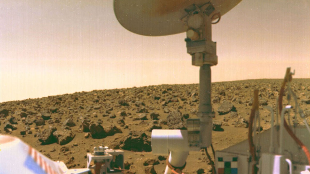 White space probe instruments and mechanical parts, with red Martian landscape behind.